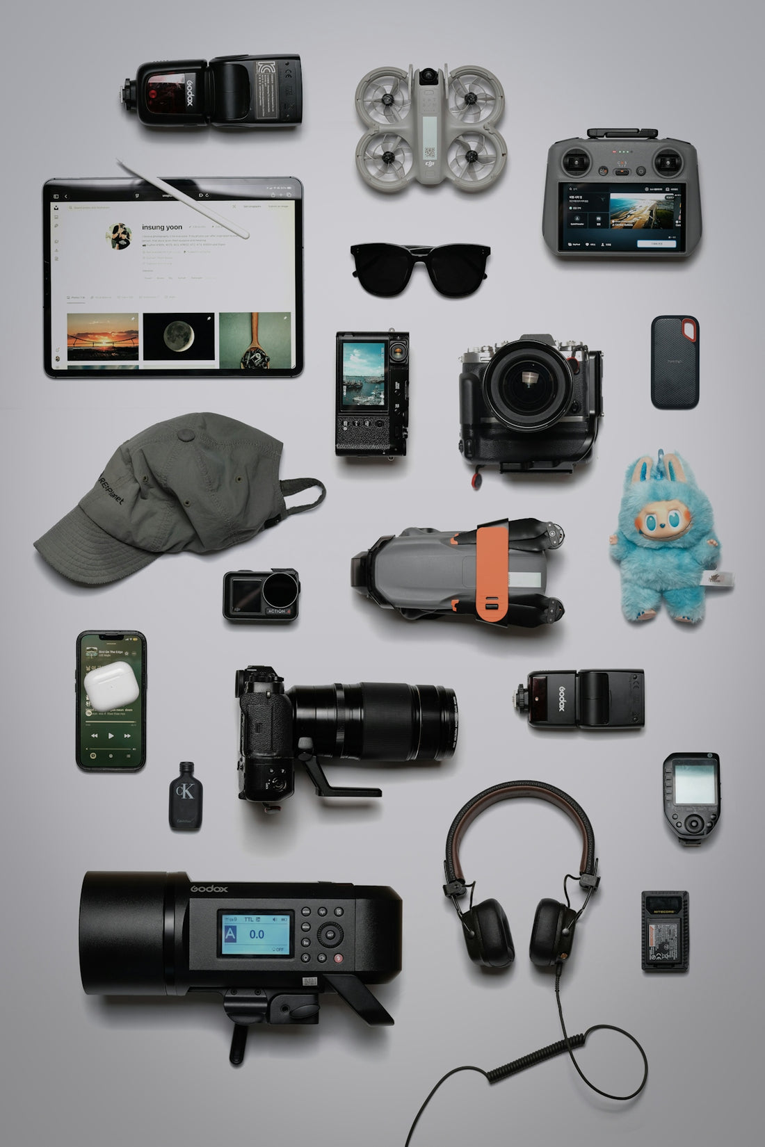 Flat lay of photography and tech gadgets on a grey background