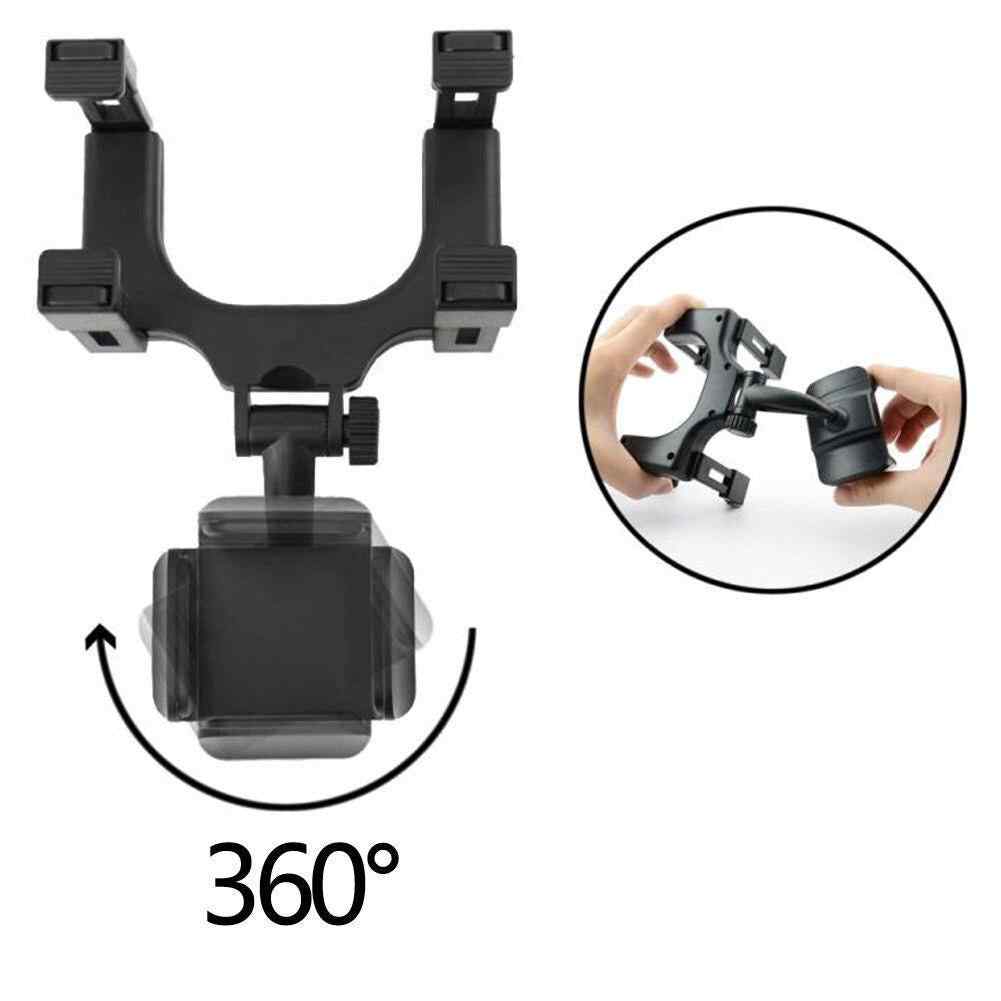 Black phone mount attached to car rearview mirror close-up view